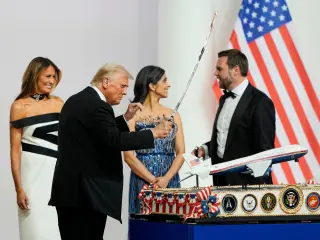 El presidente Donald Trump sostiene un sable después de usarlo para cortar un pastel en el baile inaugural del Comandante en Jefe en Washington